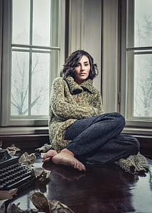 woman sitting beside window thumbnail