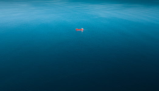 red boat sailing on body of water thumbnail