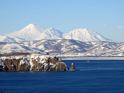 snowy mountain near water under clear day sky thumbnail