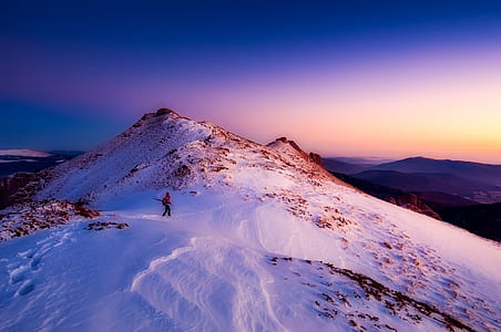person walking on snow-covered mountain thumbnail