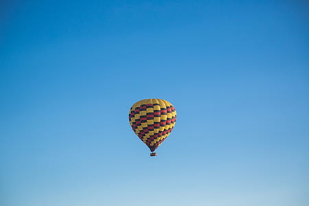 hot air balloon flying under blue sky thumbnail