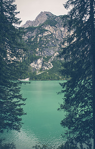 landscape photography of marble body of water near rocky mountain surrounded by trees thumbnail