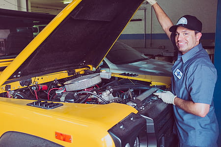 smiling man repairing yellow vehicle thumbnail