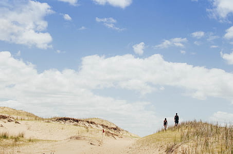two person standing near grass field under cloudy sky thumbnail