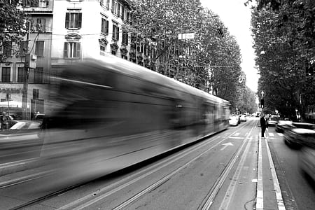 panning photography of man standing on road near cascading train thumbnail