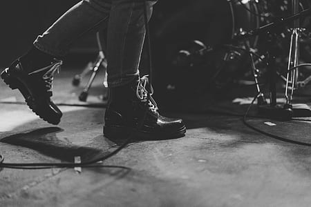 grayscale photo of person standing beside drum kit thumbnail