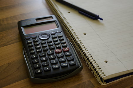 black graphing calculator beside spiral note book thumbnail