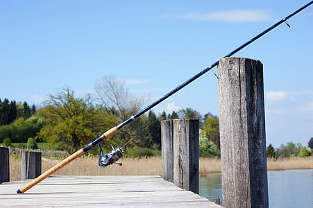 beige and black fishing rod leaning on dock thumbnail