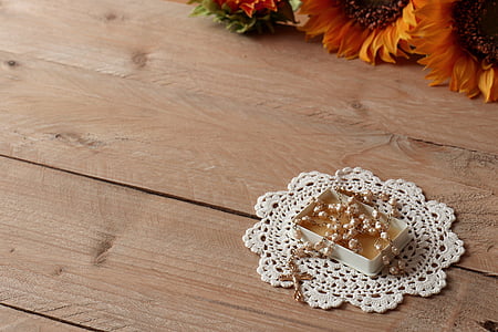 gold rosary in box on wooden table thumbnail