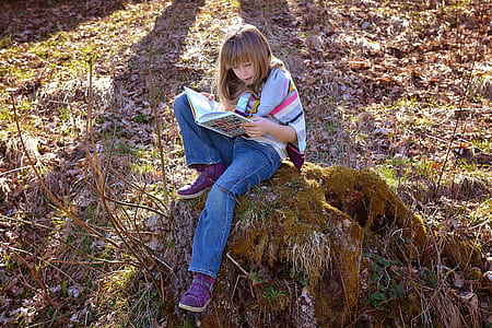 girl wearing blue jeans holding book thumbnail