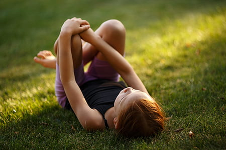 girl lying down on green grass thumbnail