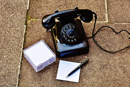 black rotary phone beside pen on floor thumbnail