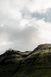 brown rock cliff under cloudy sky thumbnail