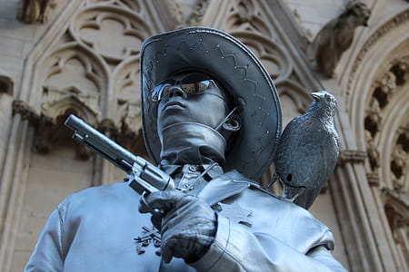 Selective Focus Photography of Cowboy Holding Revolver Pistol Statue thumbnail