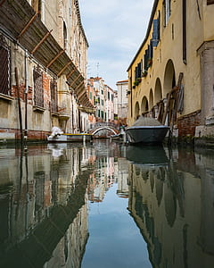 gray boat parked near beige building during daytime thumbnail