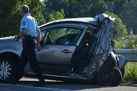 man passing near wrecked car on road during daytime thumbnail