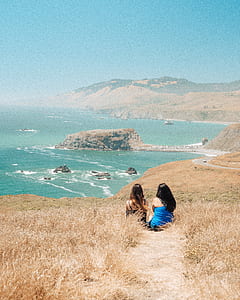 two women wearing blue and black spaghetti strap dresses thumbnail