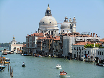 boats on blue body of water near concrete buildings thumbnail