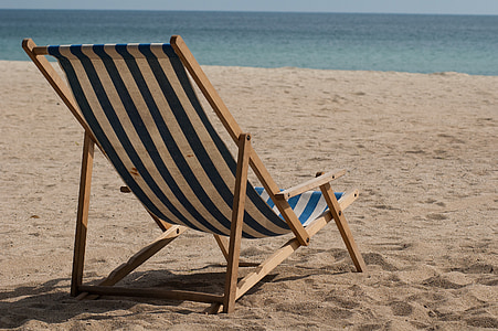 blue, white, and brown striped lounge chair on white sand during daytime thumbnail