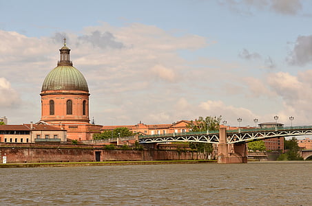 brown and green domed building near river landscape photography thumbnail