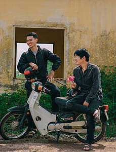 Two Man Standing Near White and Black Underbone Motorcycle thumbnail