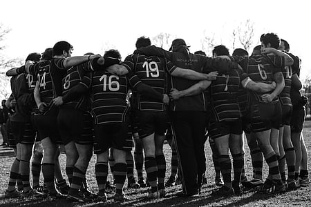 grayscale photography of group of men in huddle thumbnail