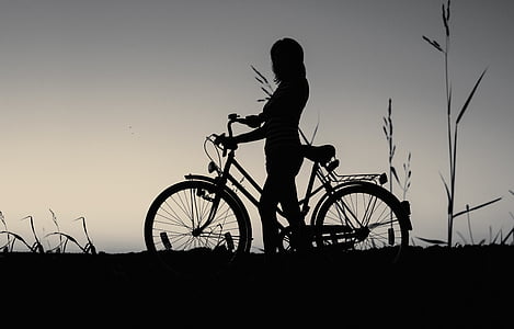 silhouette photograph of person holding bicycle thumbnail