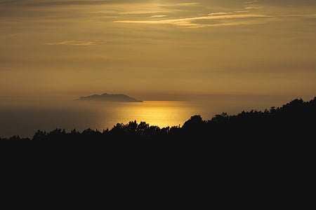 body of water, island, and clouds during sunset thumbnail