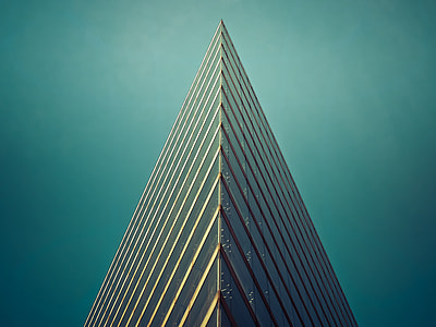 triangle gray concrete building under cyan sky during daytime thumbnail