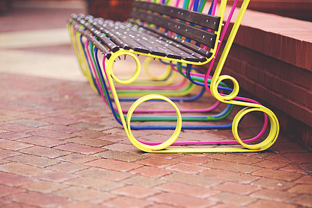 yellow, pink, and brown bench on floor thumbnail