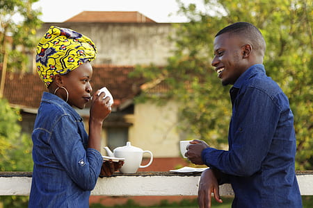 man and woman holding tea cups while standing thumbnail
