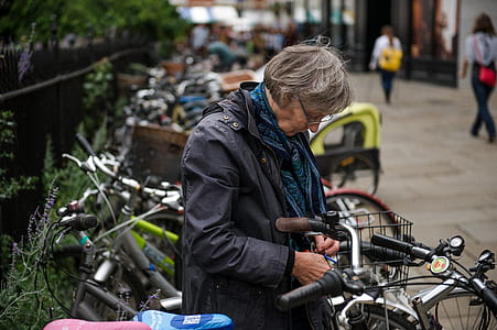 woman in gray zip-up jacket near bicycle thumbnail