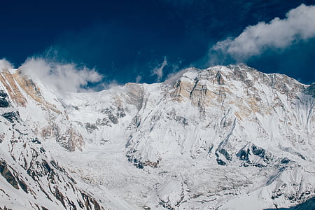 low-angled photography of snow capped mountain under blue sky thumbnail