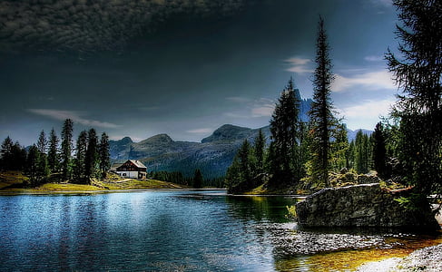 brown wooden house near lake and trees thumbnail