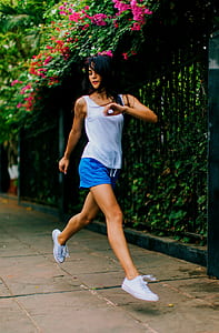 woman wearing white tank top and blue short shorts outdoors thumbnail