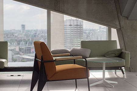orange fabric armchair near clear glass-top coffee table thumbnail