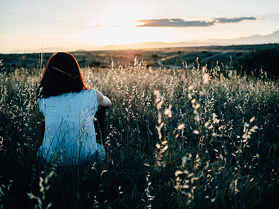 woman wearing white shirt sitting on grass field thumbnail