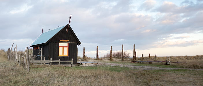 Wooden Shed With Fence Surrounded By Grass thumbnail