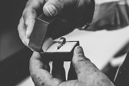 grayscale photo of person opening ring box thumbnail
