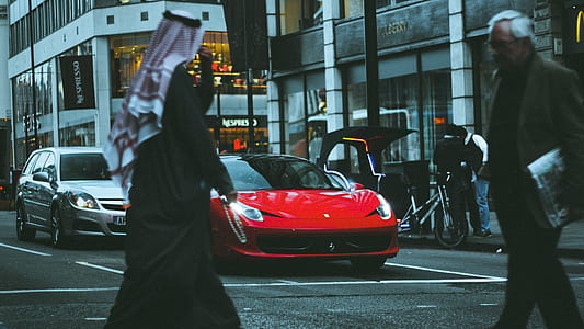 two person passing on road with vehicles beside buildings thumbnail