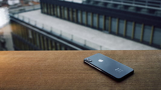 selective focus photography of space gray iPhone X placed on brown surface thumbnail