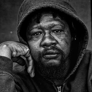 grayscaled photo of man wearing hoodie thumbnail