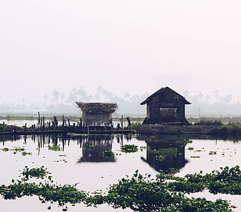 two brown houses near body of water at daytime thumbnail
