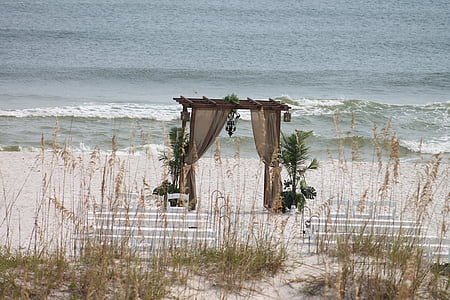 brown wooden marriage arc on seashore thumbnail