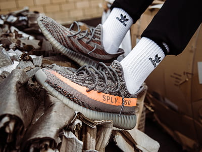 person wearing orange Yeezy Boost 350 v2 sneakers thumbnail