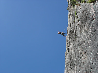 person in black top and grey shorts rock climbing during daytime thumbnail
