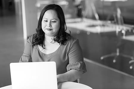 Woman in Front of Table Looking at Laptop thumbnail