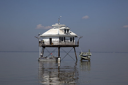 docked boat under white house in sea water thumbnail