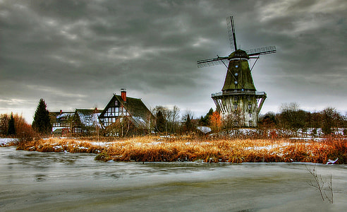 brown and grey windmill near body of water photo thumbnail