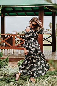 standing woman holding her hair blown by wind near gazebo thumbnail